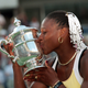 American tennis player Serena Williams kisses her trophy after winning the US open in 1999.